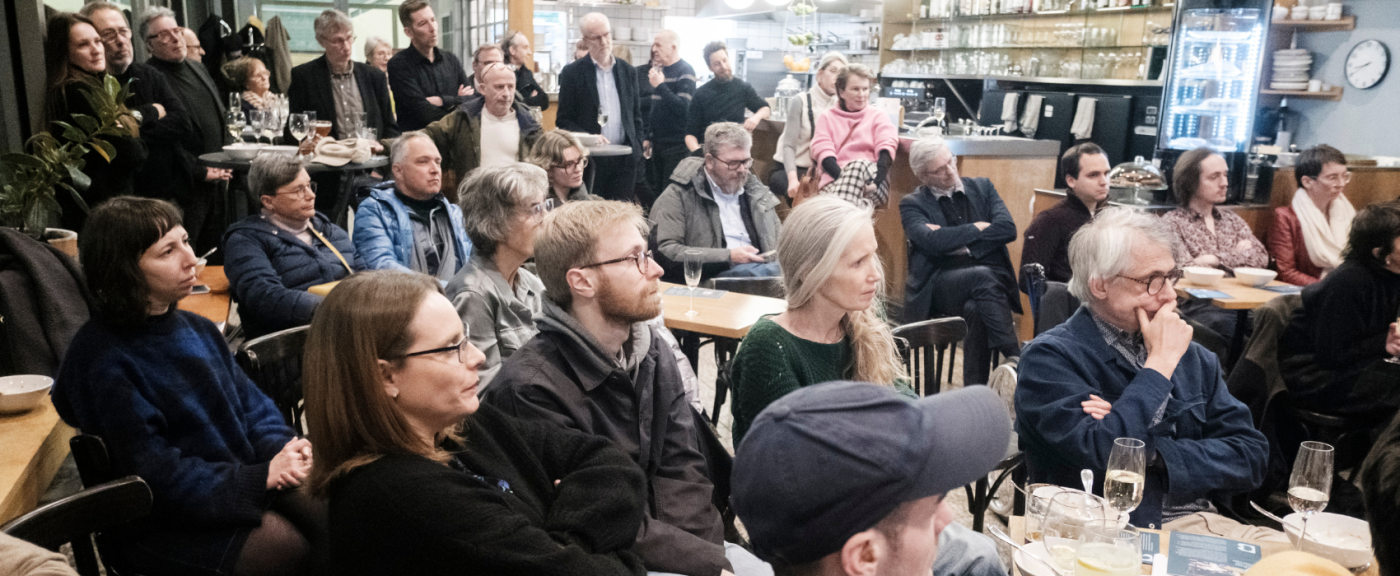 Mensen luisteren in een volle zaal
