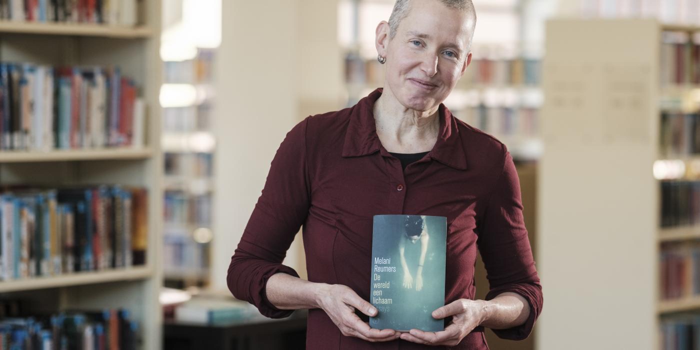 Auteur Melani Reumers poseert met haar boek 'De wereld een lichaam'