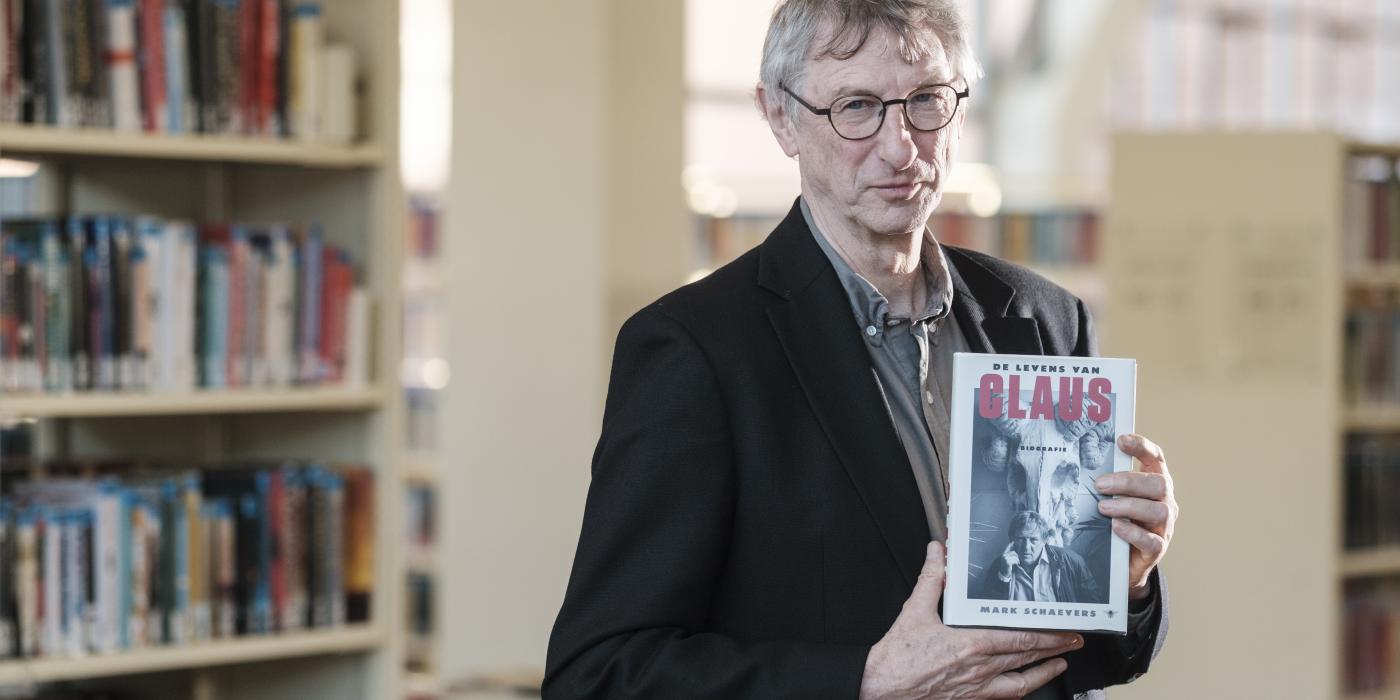 Auteur Mark Schaevers poseert met zijn boek 'De levens van Claus'