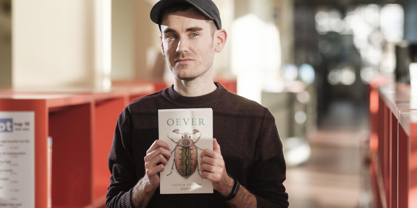Auteur Ludwig Volbeda poseert met zijn boek 'Oever'