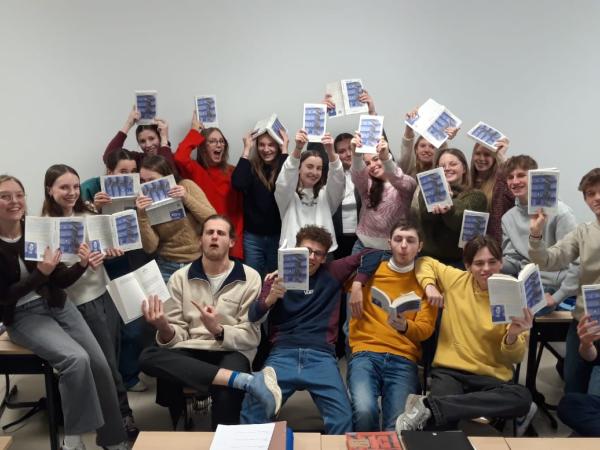 Een groep leerlingen houdt boeken van literatuurprijs de Boon in de lucht