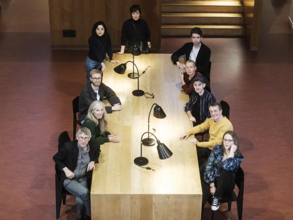 De genomineerden voor de Boon 2025 zitten samen rond een houten tafel